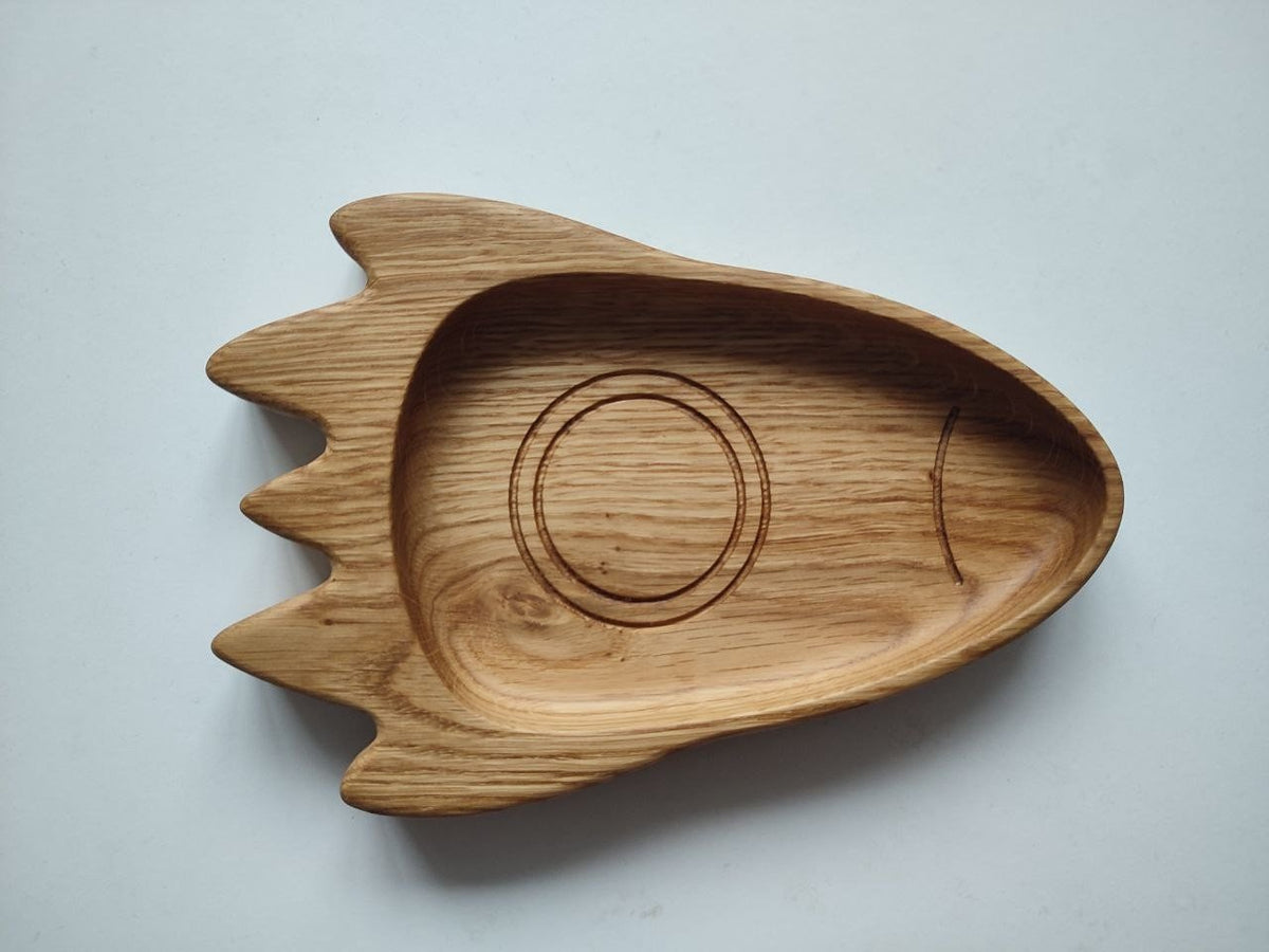 3. Top view of a wooden rocket-shaped plate for kids, highlighting the smooth, hand-polished surface and natural wood grain