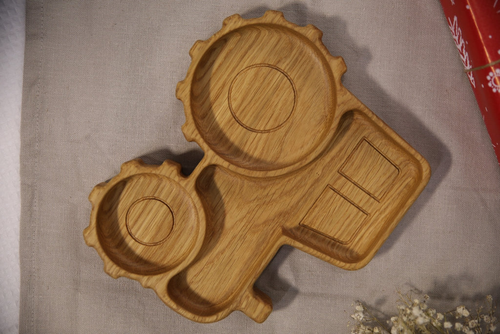 4. Flat lay of wooden tractor-shaped plate with compartments, emphasizing detailed carving and natural wood texture