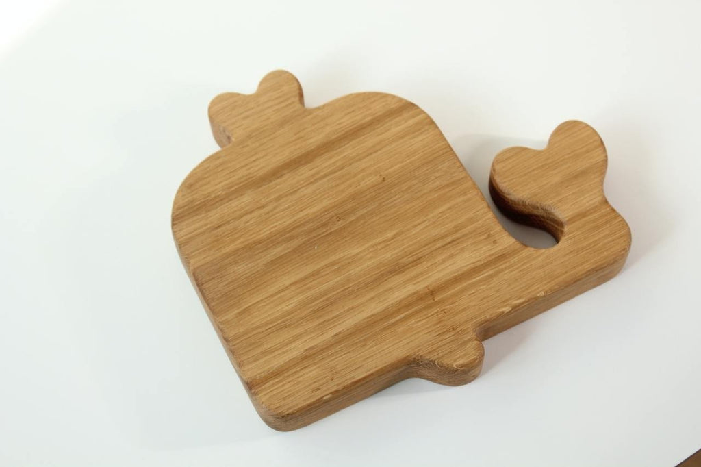 2. Back view of a wooden whale-shaped plate for kids, displaying the smooth, polished surface and natural wood grain on a white background.