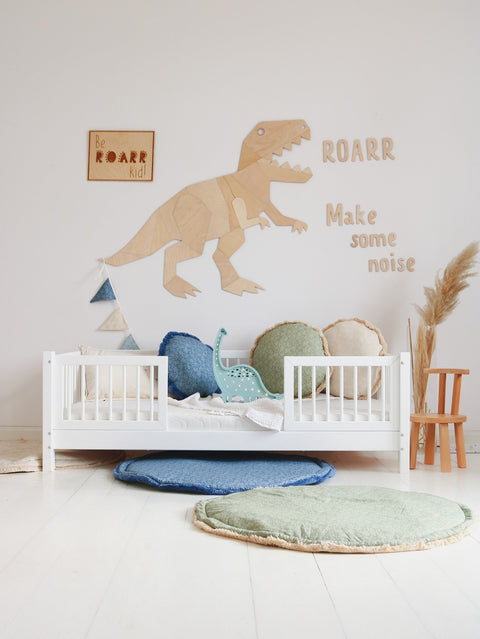 1. Children's room with 'Be Roarr Kid' wooden poster, dinosaur wall art, and colorful cushions on white bed
