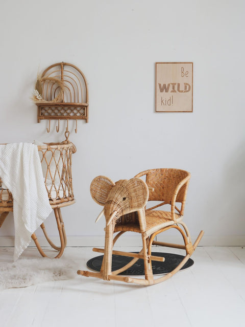 2. Nursery with wooden poster 'Be Wild Kid' on wall, elephant rocking chair, and wicker crib
