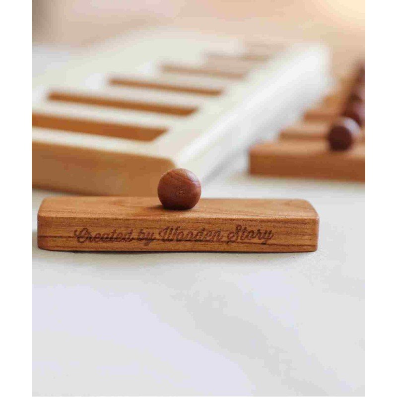 3. Close-up of a Wooden Story puzzle block with knob, engraved with 'Created by Wooden Story', on a blurred background