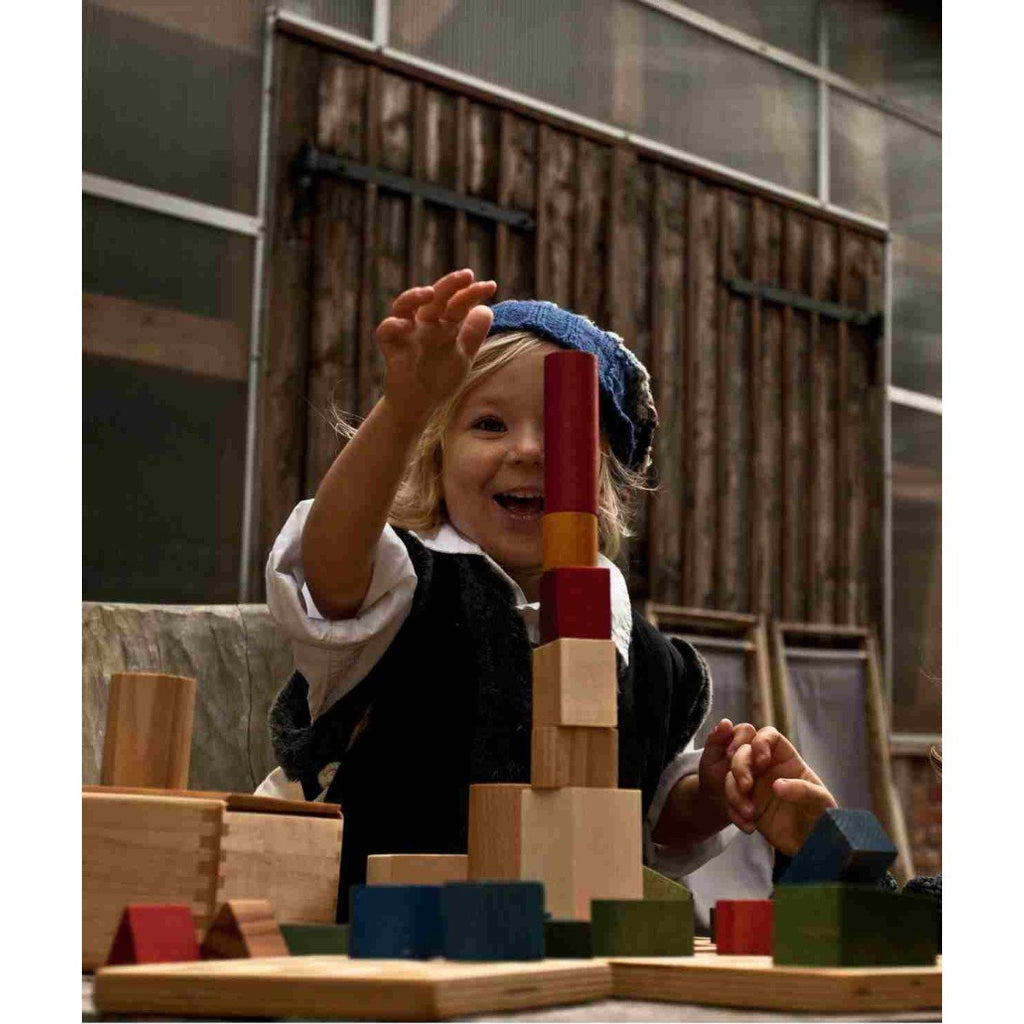 1. Child playing with colorful wooden blocks, smiling and stacking them in a creative setting