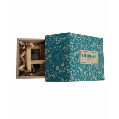 4. Fieldfare wooden rattle partially inside open blue decorative box, highlighting eco-friendly packaging