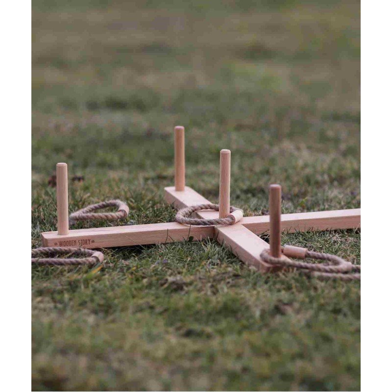 2. Wooden ring toss game set up on grass with braided rings around posts