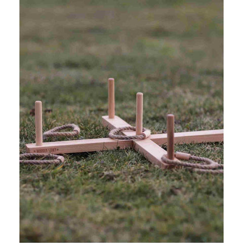 2. Wooden ring toss game set up on grass with braided rings around posts