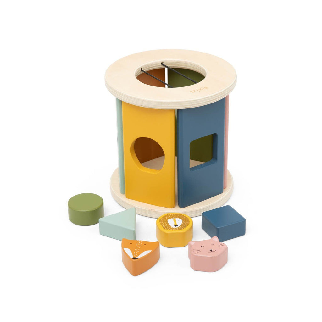 3. Studio shot of Trixie Baby wooden rolling shape sorter with assorted colorful shapes displayed around it