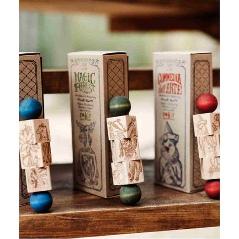 2. Three wooden spinning puzzles with colorful ends displayed on a wooden shelf, featuring intricate engravings