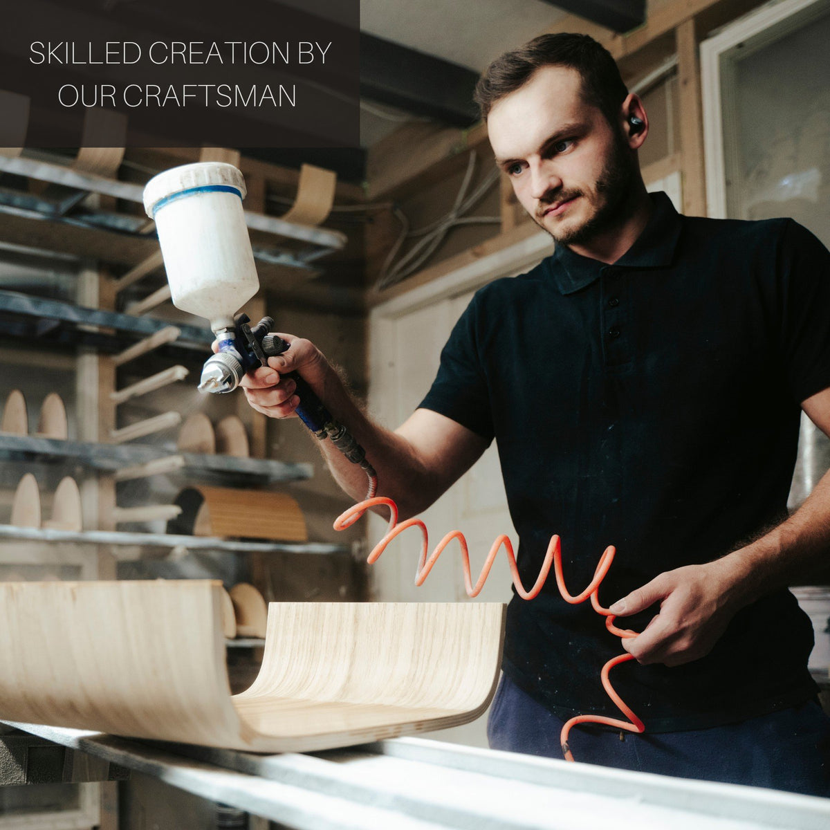 1. Craftsman applying finish to wooden step stool in workshop, showcasing handmade quality
