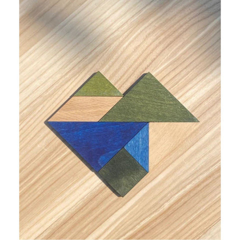 2. Wooden Story tangram pieces in cold colors forming a heart shape on a wooden surface