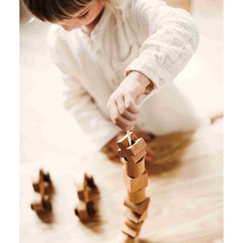 1. Child stacking wooden blocks using Wooden Story threading needle