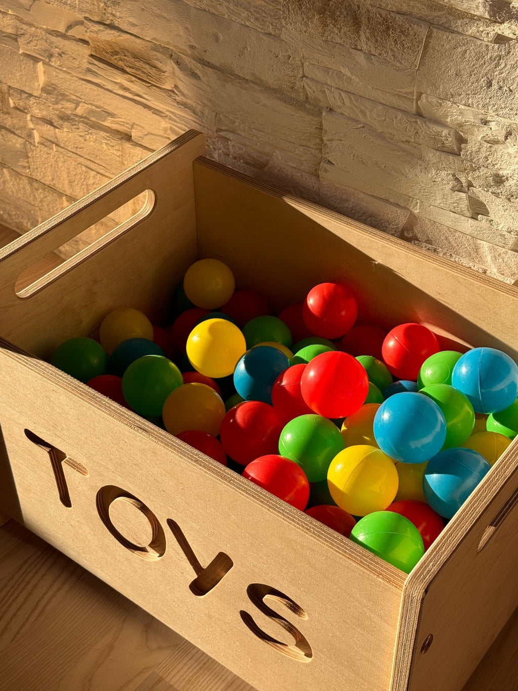 2. Wooden toy box filled with colorful balls showing spacious interior and 'TOYS' cutout