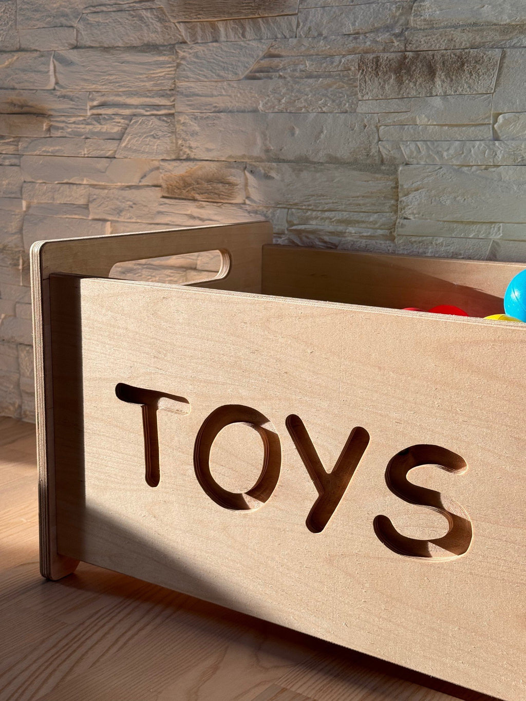 3. Close-up of wooden toy box with 'TOYS' cutout showing smooth handle and natural wood finish