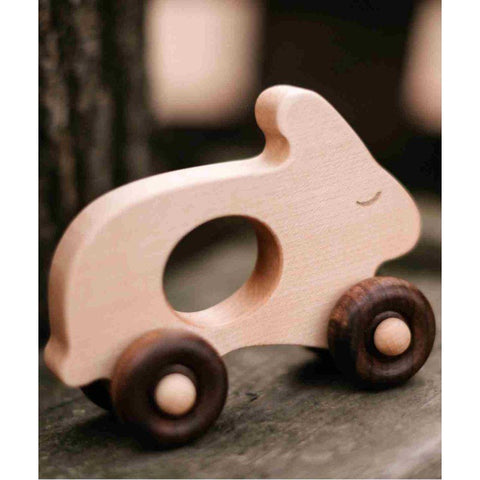 1. Wooden rabbit toy on wheels placed on wooden surface with blurred background