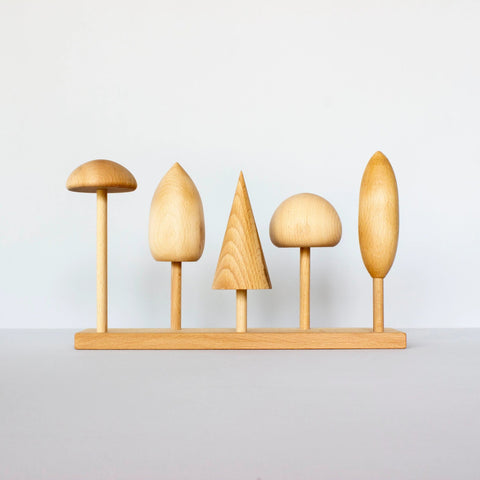 2. Wooden Story tree crown puzzle with five distinct wooden tree shapes on a base, displayed in a studio setting