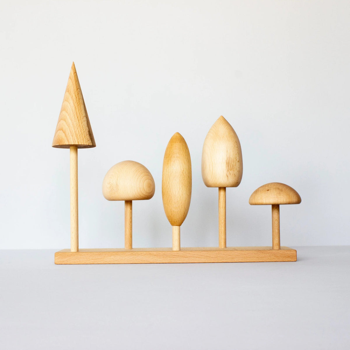 8. Wooden Story tree crown puzzle with five wooden tree shapes on a base, displayed in a studio setting