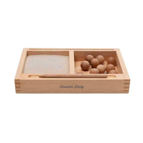 2. Side view of Montessori sand writing tray by Wooden Story, showing sand section, wooden balls, and engraved brand name on the side.