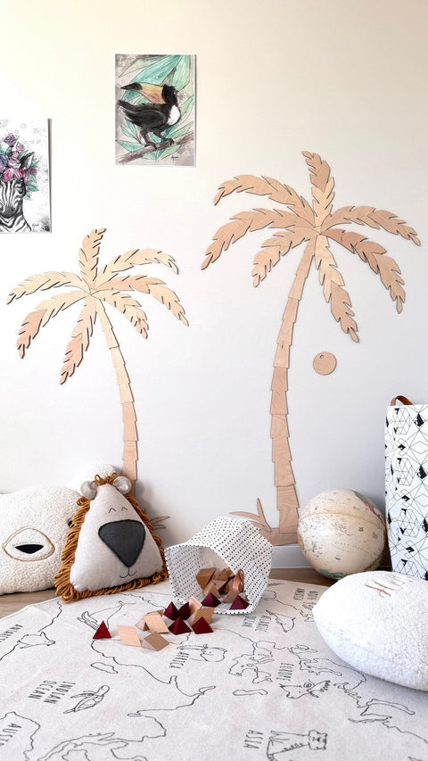 1. Children's room with two wooden palm tree wall decors, natural plywood, surrounded by plush toys and a play mat, creating a tropical theme
