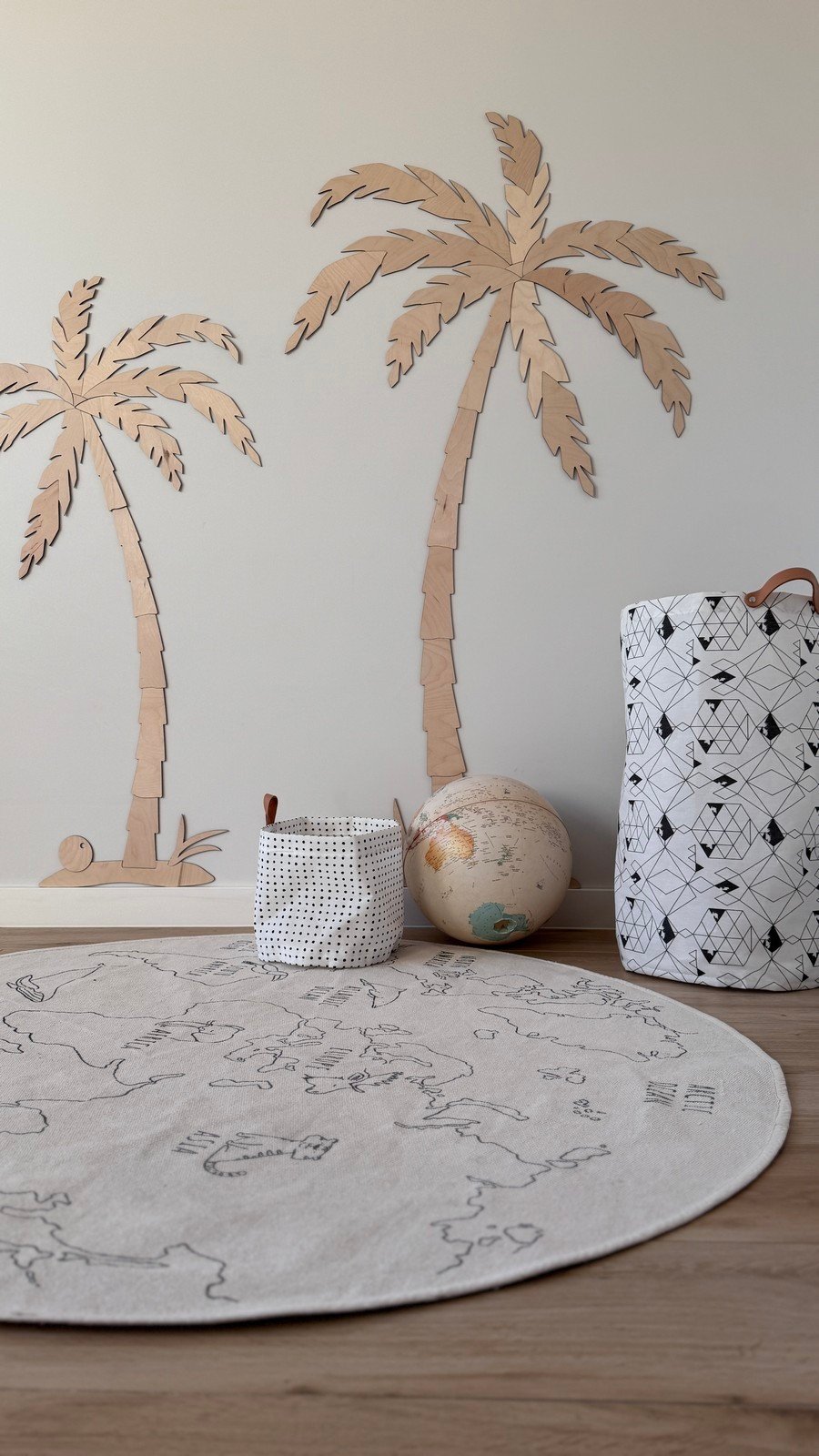 5. Children's room with two wooden palm tree wall decors, natural plywood, featuring a round play mat and storage baskets