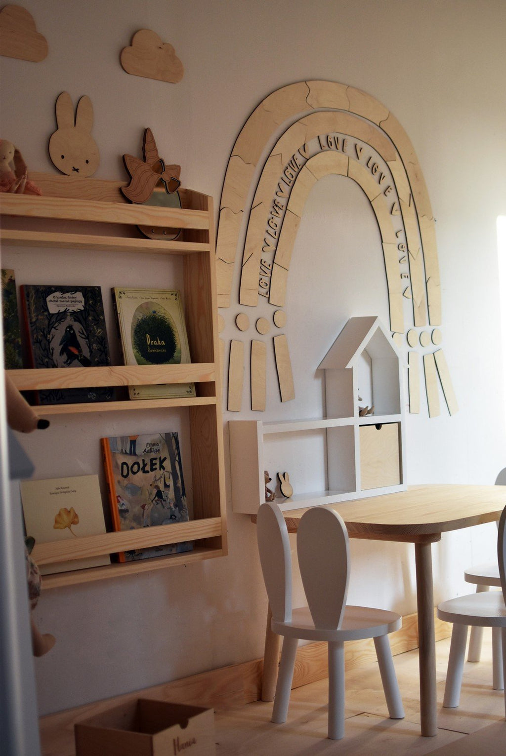 5. Children's room with wooden rainbow puzzle wall decoration above a bookshelf and table, adding a magical touch