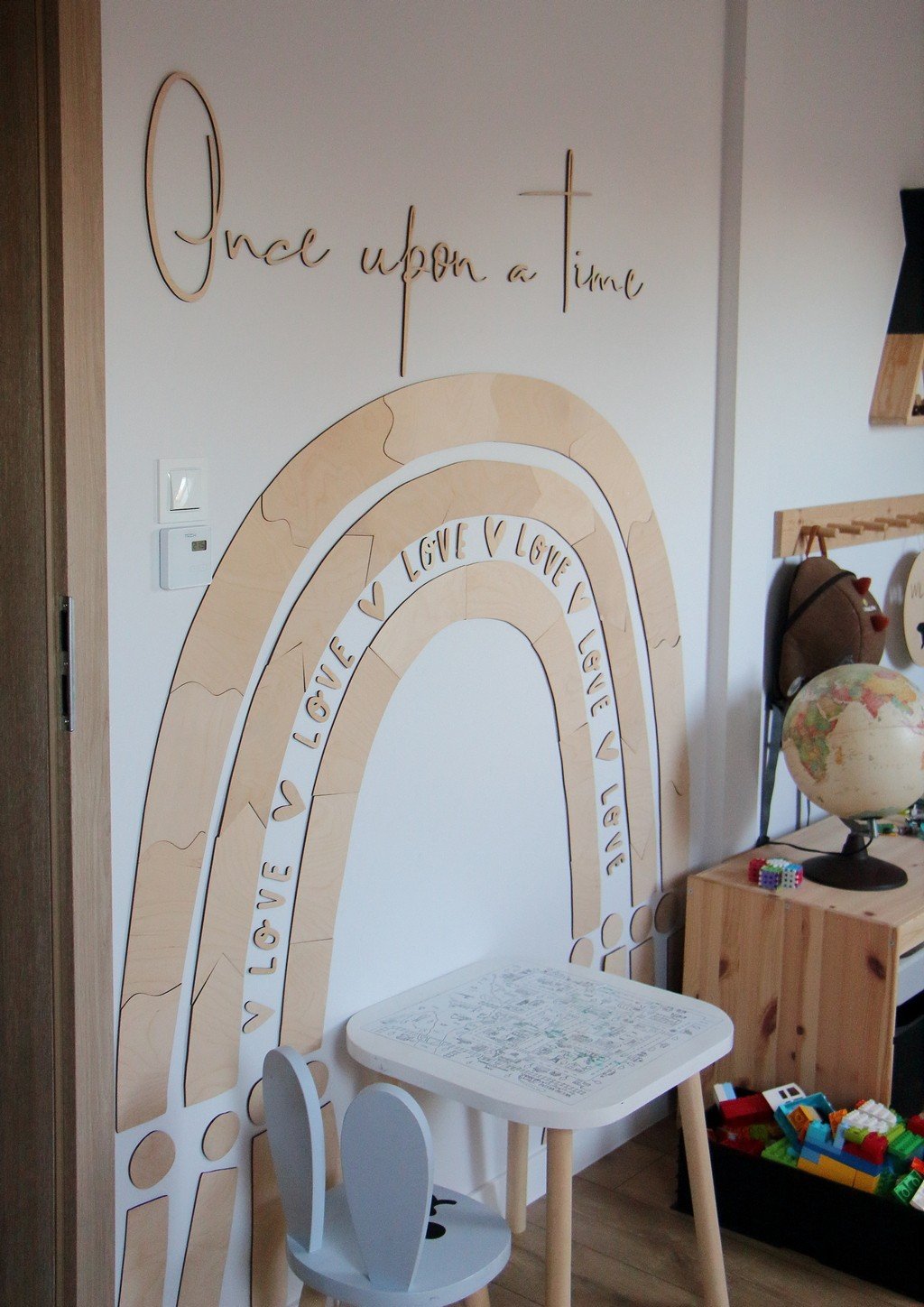 3. Wooden rainbow puzzle wall decoration in a playroom with a small table and toys, featuring the phrase 'Once upon a time'