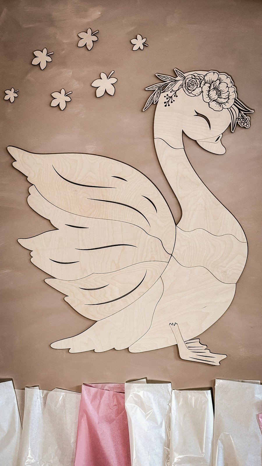 2. Wooden swan wall decoration with floral accents on a beige wall