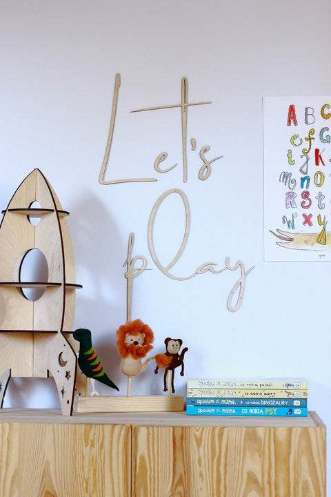 1. Children's room with natural plywood 'Let's Play' wall sign above wooden toys and books on a shelf