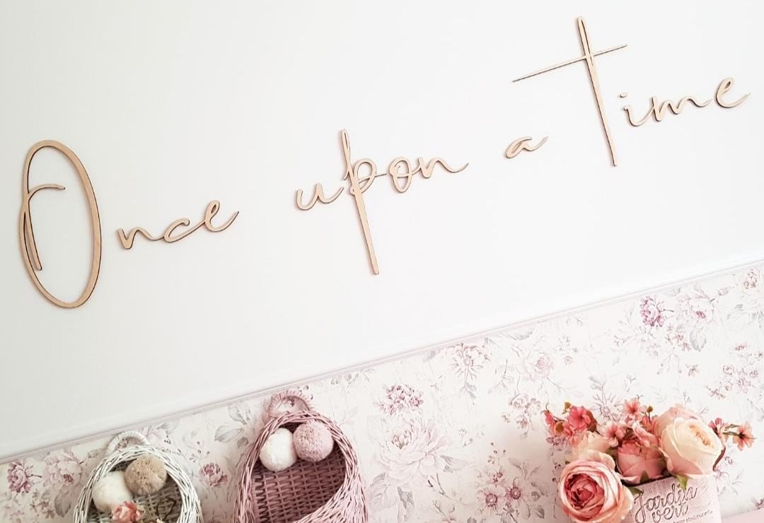 3. Close-up of 'Once upon a time' wooden wall sign on a floral wallpaper background, adding a magical touch to a child's room decor
