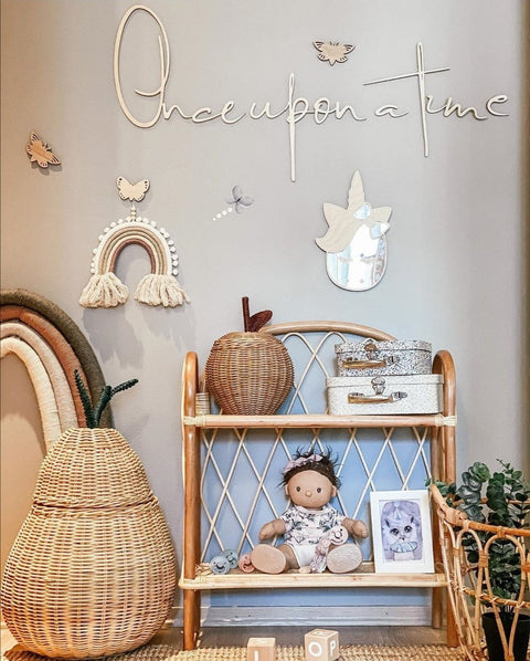 2. 'Once upon a time' wooden wall sign in a child's room with wicker furniture, toys, and decorative elements, enhancing a fairytale theme