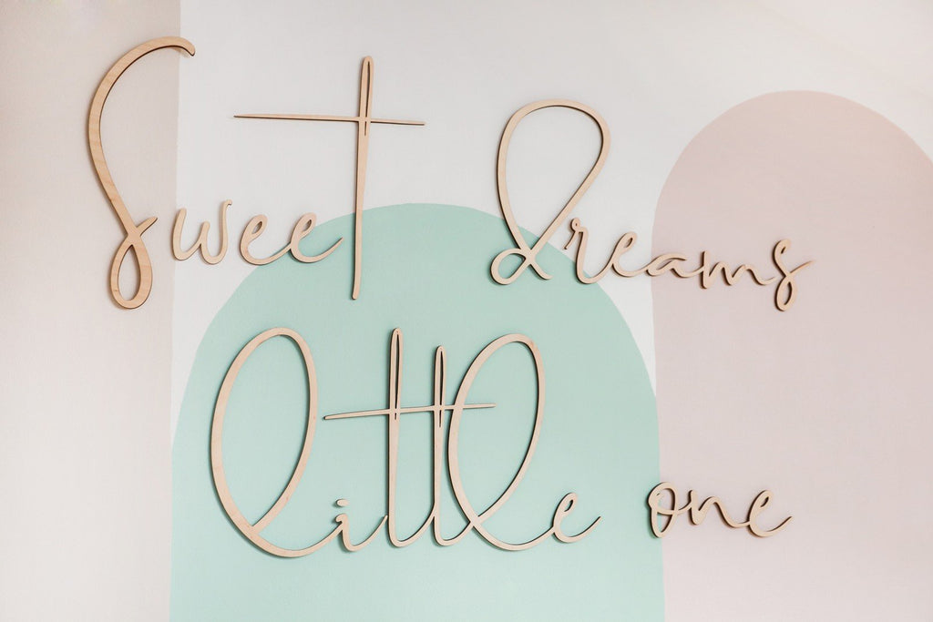3. Close-up of wooden 'Sweet Dreams Little One' sign on pastel painted wall
