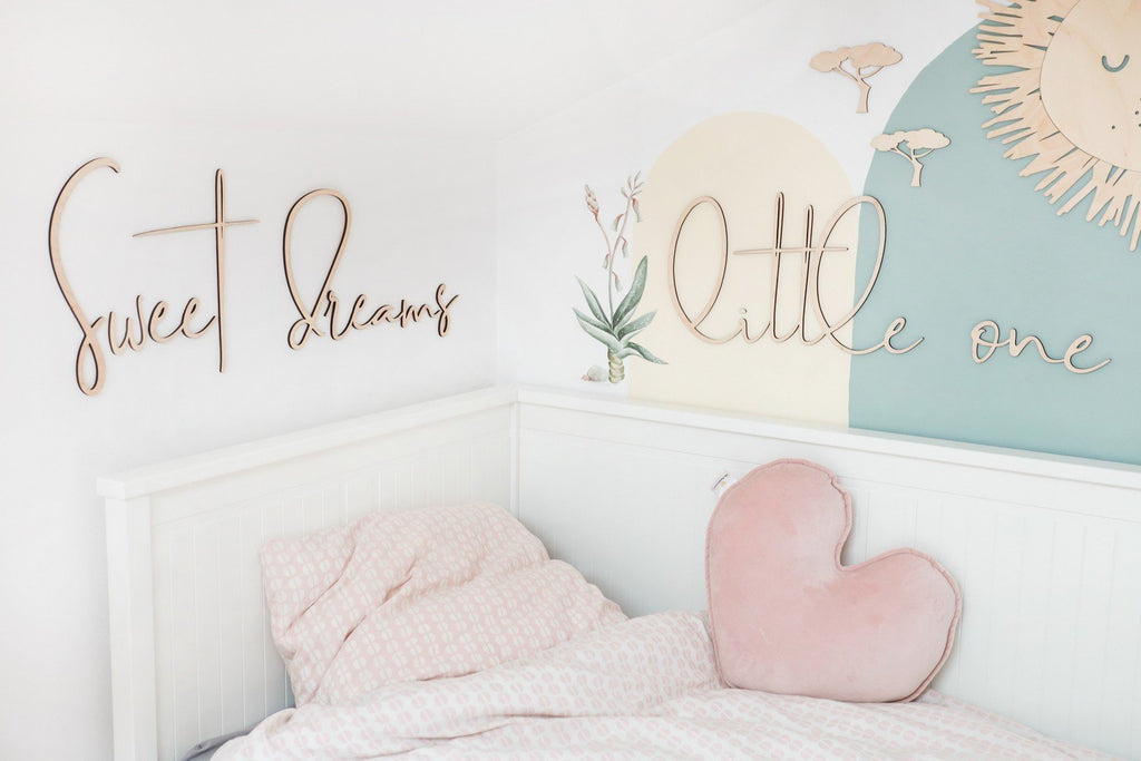 5. Bedroom with wooden 'Sweet Dreams Little One' sign above bed with pink heart pillow and pastel wall art