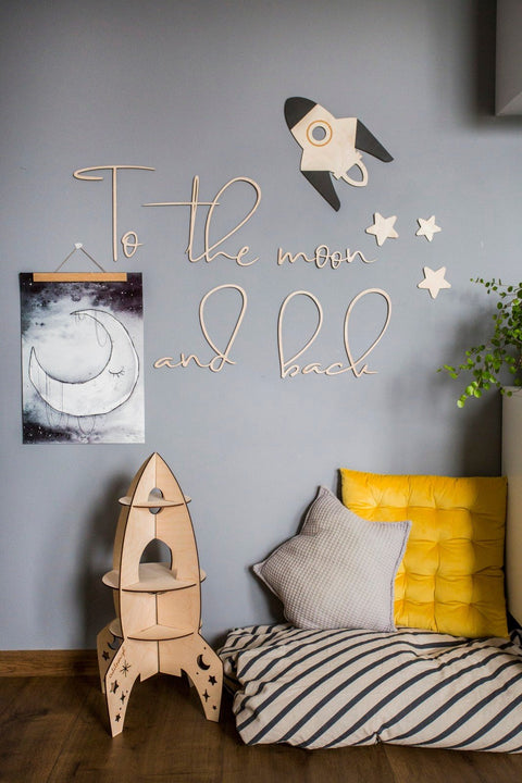 2. Child's room with wooden 'To the moon and back' wall sign, rocket decor, and yellow cushion, creating a cozy and imaginative space.