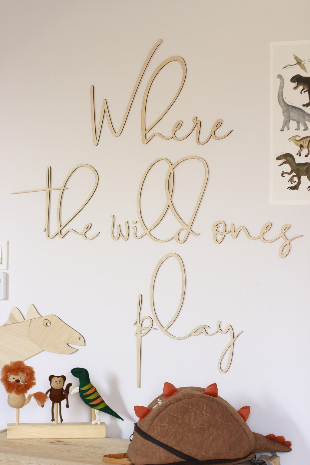 2. Wooden wall sign reading 'Where The Wild Ones Play' in child's room with dinosaur and animal decor