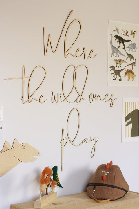 1. Wooden wall sign with 'Where The Wild Ones Play' inscription in child's room with dinosaur and animal toys on shelf