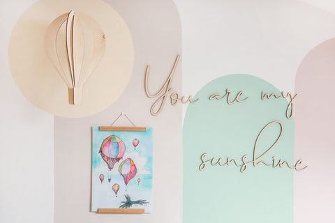 3. Close-up of 'You Are My Sunshine' wooden wall sign with colorful hot air balloon artwork in a child's room.