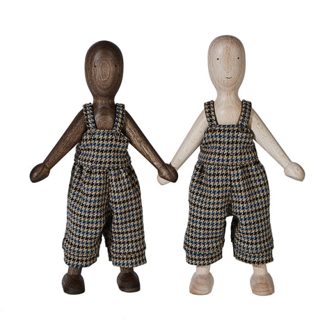 1. Two wooden dolls in walnut and beech finish wearing houndstooth pants, standing side by side on a white background