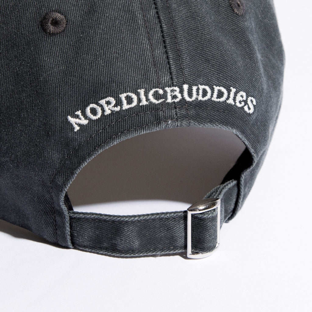 6. Close-up of NordicBuddies logo and adjustable strap on grey denim cap