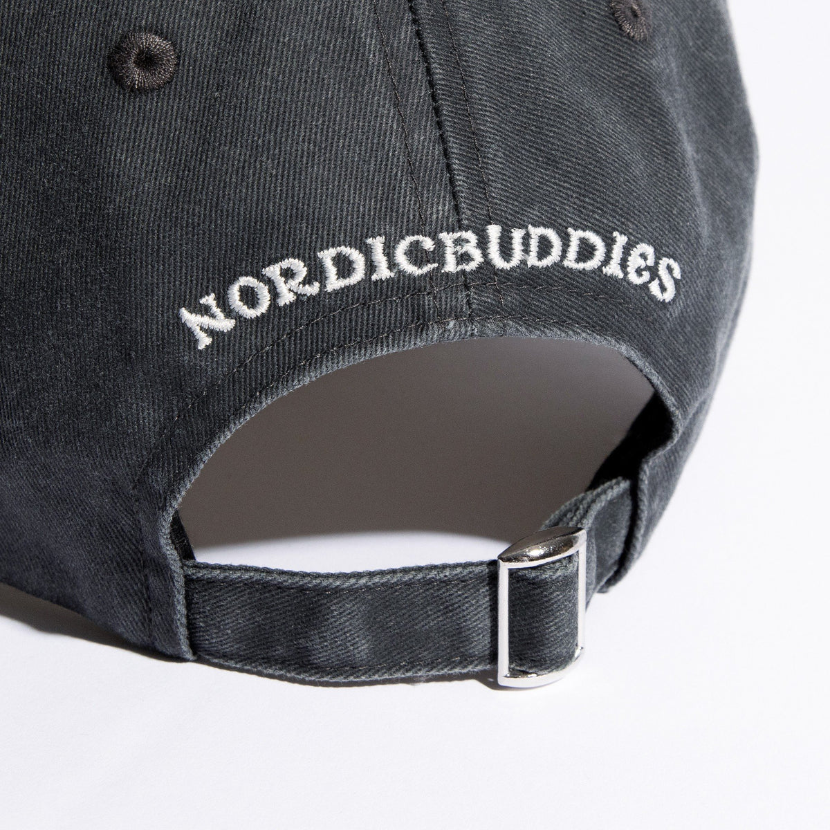 6. Close-up of NordicBuddies logo and adjustable strap on grey denim cap