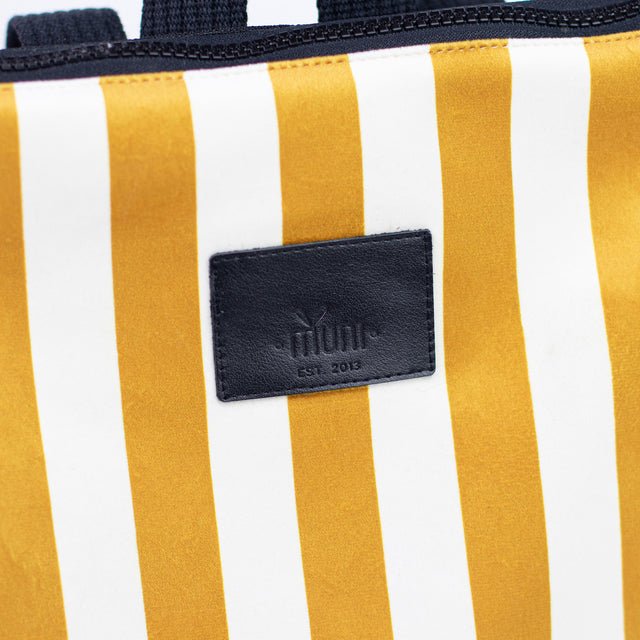 6. Close-up of Muni logo on striped mustard and white backpack