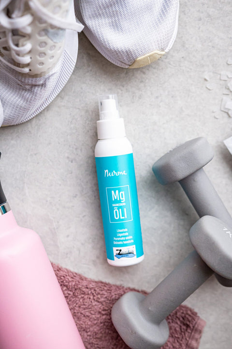 3. Nurme Zechstein Inside Magnesium Oil 100ml bottle on gym floor with dumbbell, towel, and sneakers