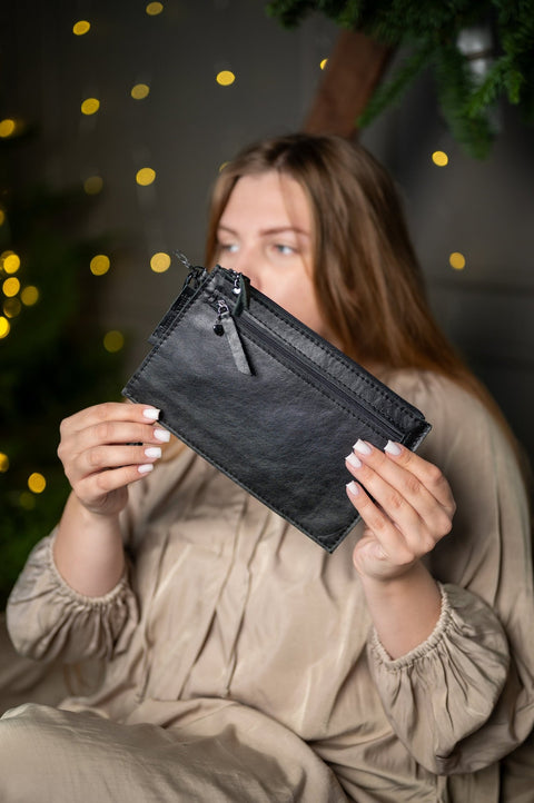 4. Close-up of Zelma Kraft small black wristlet wallet, showcasing sleek design and zip pockets