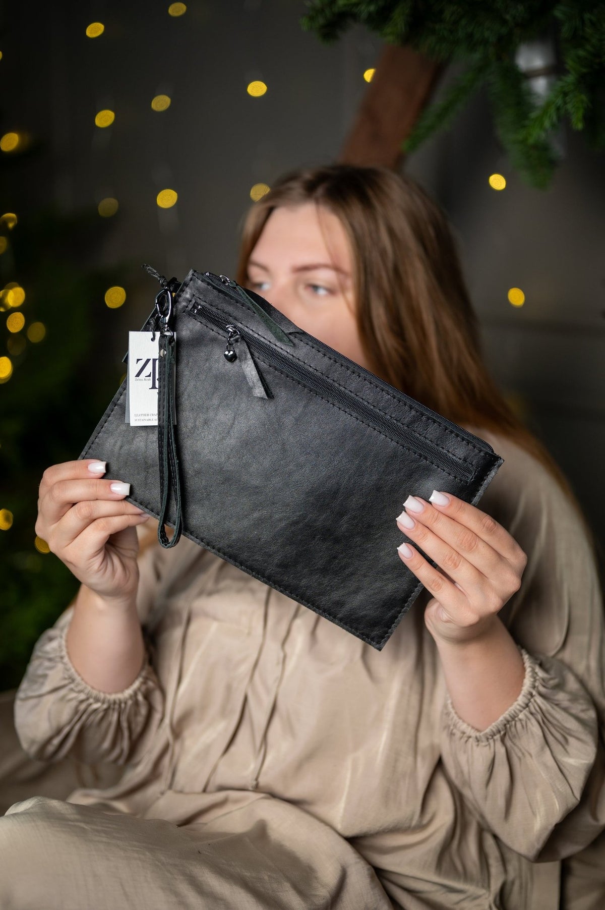 3. Close-up of Zelma Kraft medium black wristlet wallet with tag, featuring natural leather texture