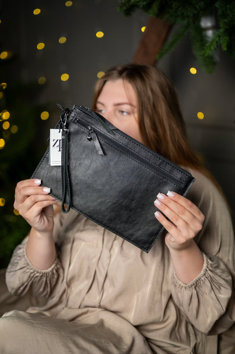 3. Close-up of Zelma Kraft medium black wristlet wallet with tag, featuring natural leather texture