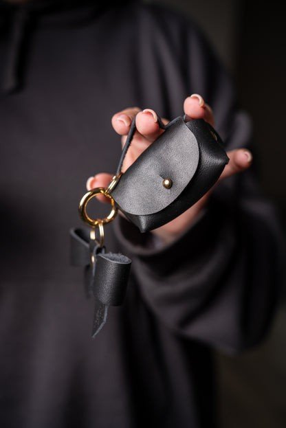 13. Zelma Kraft mini leather charm with bow and gold hook, held in hand, showing detail