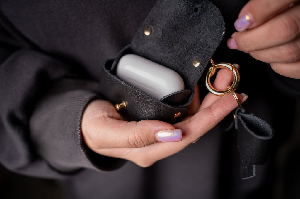 7. Zelma Kraft mini leather charm with bow, open to reveal interior, held in hand