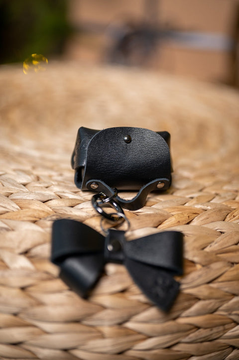 5. Zelma Kraft mini leather charm with bow, displayed on woven surface, highlighting design