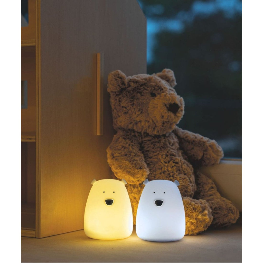 1. Set of two mini bear night lights in white and arctic blue next to a brown teddy bear on a windowsill