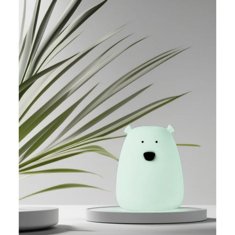 3. Arctic green mini bear light on a white platform with green plant leaves in the background